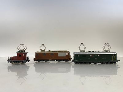 trois petits trains assis côte à côte sur une surface blanche