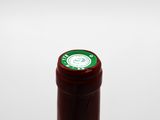 close up of a bottle of red wine with a green label