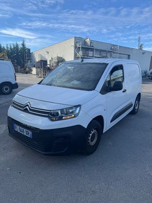 une camionnette blanche garée sur un parking à côté d'un bâtiment
