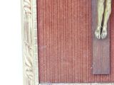 a gold statue of jesus on a cross on a red wall