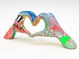 a figurine of two hands making a heart shape