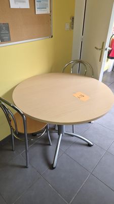 une table et des chaises dans une pièce où se trouve un tableau en liège accroché au mur