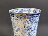 a blue and white vase sitting on a black table