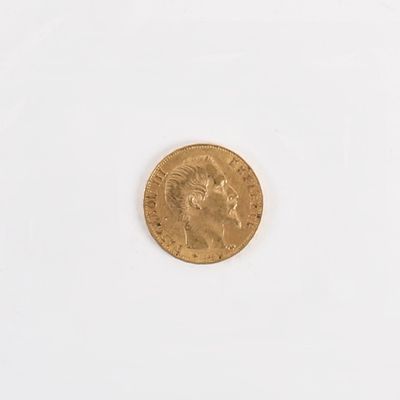 gros plan d'une pièce d'or sur une surface blanche