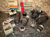 many different cameras and lenses on the table