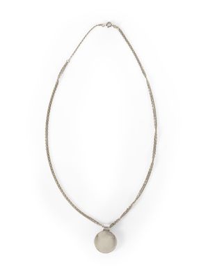 un collier blanc orné d'un disque en argent, monté sur une chaîne en argent