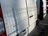 many white vans parked in a row on the side of the road