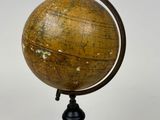 an old globe on a black stand with a white background