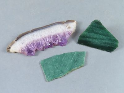 deux morceaux de savon vert et violet à côté d'un morceau de savon violet