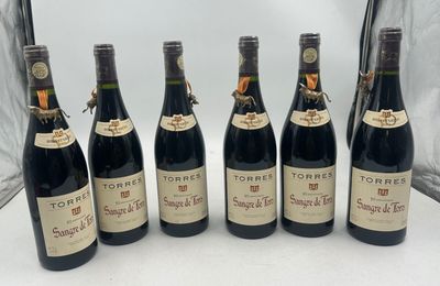 six bottles of wine are lined up in a row on a table