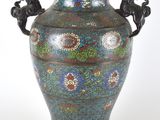 un vase muni d'une anse ornée d'un motif