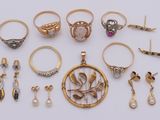 various rings and earrings are arranged on a white surface