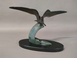 statue of a bird on a curved base with wings outstretched