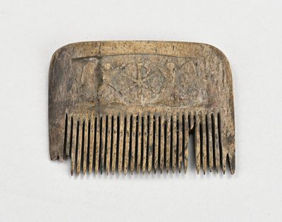 un peigne marron orné d'un motif sur un fond blanc