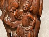 a wooden statue of a man and a woman holding a child