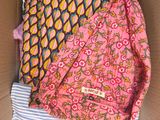 an open cardboard box filled with clothes and a pink bag