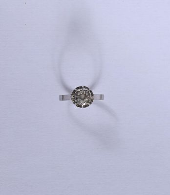 une image d'une bague en diamant sur une surface blanche