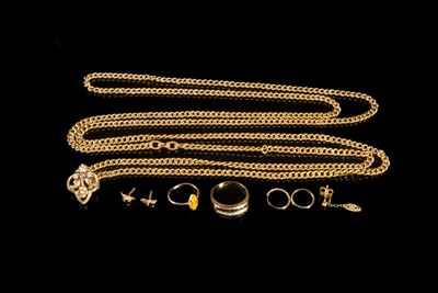 un gros plan sur une chaîne en or à laquelle sont accrochés une bague et un collier