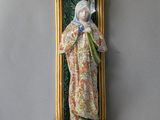 an image of a statue of the virgin mary of guadalupe hanging on a wall