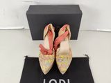 une paire de chaussures roses et dorées posées sur un sac noir