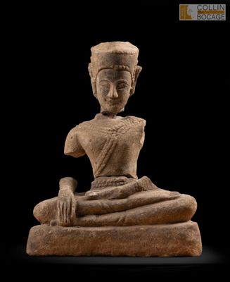 une statue représentant une personne assise sur un rocher