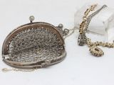 a silver purse with a chain around it on a table
