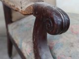 a chair with a wooden arm rest and a cushion on it