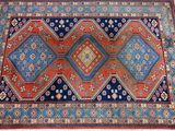 an orange, blue, and red rug on a wooden floor