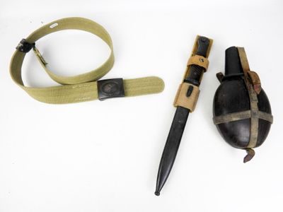 un couteau, une ceinture et un couteau posés sur une surface blanche