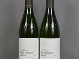 two bottles of wine sitting on top of a table next to each other