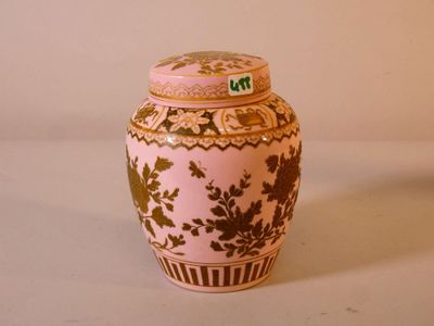 a pink and gold vase sitting on a white surface
