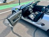 une voiture argentée dont la portière est ouverte sur un parking