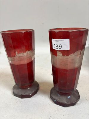 une paire de vases en verre rouge posés sur un comptoir blanc