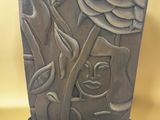une sculpture représentant un visage sur un bloc de pierre