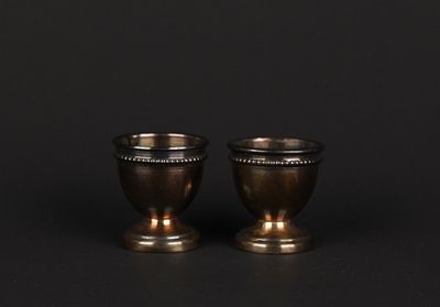paire de tasses anciennes en métal argenté sur fond noir