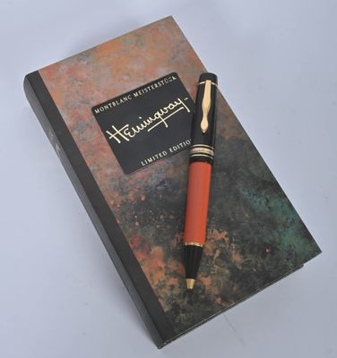 a book with a pen on top of it on a table