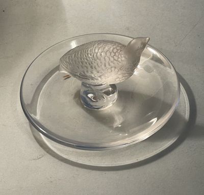 a glass plate with a fish figurine on it