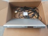 a laptop in a cardboard box with wires on it