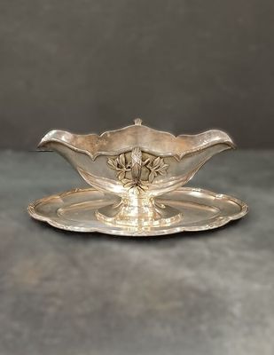 un service en argent ancien composé d'une assiette et d'une soucoupe posée dessus