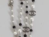 a long necklace with pearls and black and white beads