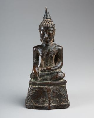 a bronze statue of a seated buddha
