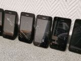five cell phones are lined up in a row on the floor