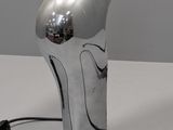 a silver object on a white table with a black cord