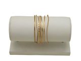 des bracelets posés sur un présentoir blanc, sur fond blanc