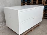 a close up of a white chest of drawers in a warehouse