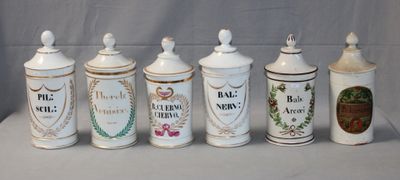 five white and gold canisters are lined up on a table