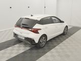 the rear end of a white car parked in a garage