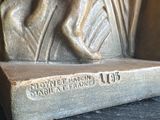 a statue of a woman holding a book on a table