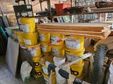 several buckets of paint are stacked on top of each other in a garage