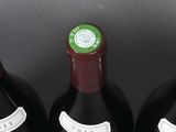 four bottles of wine are lined up in a row